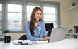 © matinee - Confident businesswoman typing on computer and managing tasks efficiently.