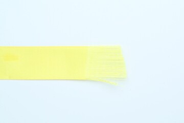 Wall Mural - Beautiful yellow ribbon on white background, top view. Space for text