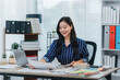 © Kritdanai - Smiling Asian Woman Working at Desk