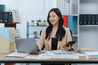 © Kritdanai - Asian Woman Working with Laptop and Calculator in Office
