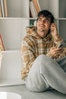 © carballo - young man at home with mobile phone and headphones
