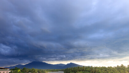Wall Mural - Cloudy sky with mountains in the background