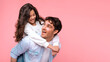 © Home-stock - Excited father giving piggyback ride to preteen daughter, having fun posing on coral studio background, panorama with copy space. loving family leisure activities