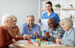 © Prostock-studio - Happy multiracial elderly men and women sitting around table and drawing at nursing home, doing arts and crafts together, young lady nurse assisting group of senior people, copy space