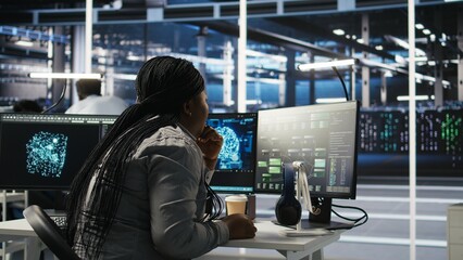 Server room specialist applies artificial intelligence technology to minimize system downtime. African American worker develops and deploys AI solutions to optimize data center equipment, camera A