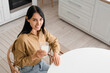 © Pixel-Shot - Beautiful young woman with glass of milk at table in kitchen