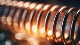 Close-up view of a shiny copper coil with warm bokeh lights.