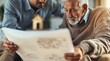 © Tonton54 - real estate agent senior clients concept. Two men discussing building plans together.