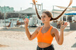 © svetograph - Woman Beach Hair Long Braids playful summer pose outdoors sunny coastal area joyful expression.