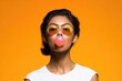 © Larisa - Bright orange backdrop enhances playful vibe of model blowing bubble gum, exuding confidence