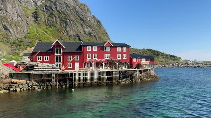 Wall Mural - Picturesque Norwegian fishing village with typical red wooden houses on the coast of the Lofoten Islands