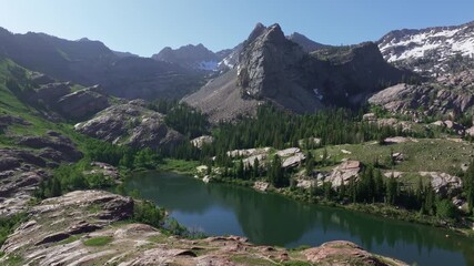 Wall Mural - Aerial drone wide shot of Lake Blanche in Big Cottonwood Canyon near Salt Lake City, Utah, on a bright green summer morning with rocky peaks, lush foliage, and Sundial Peak towering above