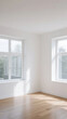 © Molang Visual - An empty room with large windows letting in natural light and a wooden floor, featuring a minimalist and clean interior.