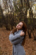 © mettus - Young Woman Embracing Herself in Autumn Forest With Peaceful Mood