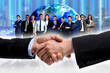 © New Africa - Partners shaking hands against group of business people and globe