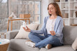 © Pixel-Shot - Young woman with vitamin B pills meditating on sofa at home