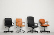 © Pixel-Shot - Different office chairs near white brick wall in room