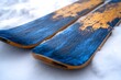 © Md Mojammel - Detailed View of Two Blue and Golden Skis Lying Flat on Snowy Surface During Winter Season