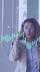 Wall Mural - Animation of financial data processing over businesswoman talking on smartphone