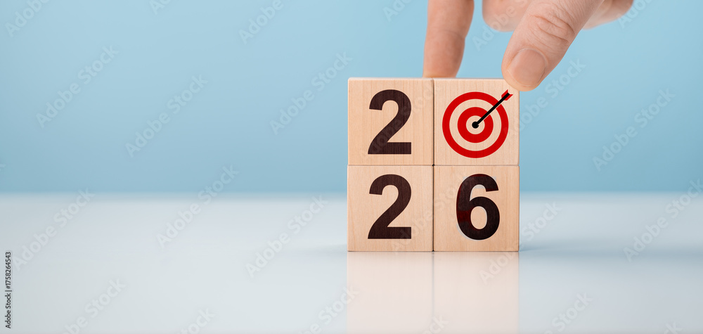 Male hand arranging wooden cubes with 2026 numbers and target symbol ...
