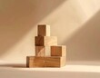 © Ardijojo - Wooden blocks artfully arranged, creating a small staircase or pyramid shape, are positioned on a neutral, light-colored backdrop with a soft, warm illumination casting gentle shadows.