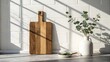 © prodip - Wooden cutting board and eucalyptus branch on kitchen counter in sunlight