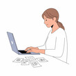 © Baskara - Donna che lavora al computer portatile con fogli sparsi sulla scrivania.