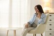© New Africa - Beautiful woman on armchair at home. Space for text
