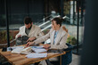 © qunica.com - Business professionals collaborating and analyzing data together at a modern workspace outdoors