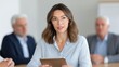 © 69 - Woman in Glasses Engaged in Business Meeting Using Tablet with Focused Expression and Professional Attire in Modern Conference Room Setting