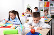 © New Africa - Children drawing at wooden desk during art lesson in elementary school