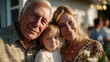 © Aliaksandra - Warm family portrait of grandparents and their granddaughter smiling together outdoors at sunset