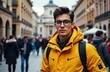 © starush - Young man in yellow jacket and glasses standing on busy city street with historic buildings and crowd