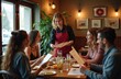 © Viktor - Waitress serves menu to group of friends in restaurant. People sit at table with food, drinks. Woman in red apron offers menu to customers. Friends smiling, looking at menu. Dining room with modern