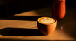 © Dinda - Aesthetic coffee latte with artistic foam pattern and a terracotta pot set in dim lighting