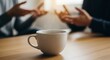 © MD NAIM ISLAM - Close up of a coffee mug on a wooden table with blurred people talking in the background