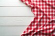 © Pete - Red checkered tablecloth on white wood table. Top view of picnic setting. Fabric texture and background. Rustic kitchen design. Empty space for copy and menu.