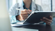 © tippapatt - Doctor using digital tablet for electronic health records, examining patient health information, working in doctor's office in modern hospital, closeup. Medical technology