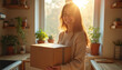 © miss irine - Young beautiful woman smiles, holding brown delivery parcel box in cozy kitchen. Warm golden sunlight streams through window. Happy receiving recent online order shipment at home. Excited for quick,