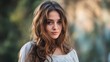 © Nataliya - Young woman with long hair posing outdoors in soft light during golden hour, surrounded by nature in a serene setting