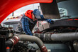 © Tomasz Zajda - Caucasian Mechanic Checks Engine in Heavy Truck During Overcast Day