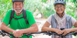 © Daniel - Portrait of couple of old and happy in love seniors looking at the camera smiling and having fun with their bikes in the nature outdoors together feeling good and healthy.