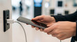 © Jahangir - A persons hands are shown plugging a charging cable into a smartphone, connecting it to a power outlet, indicating charging or data transfer
