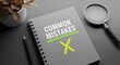 © Stocker Man - A notebook with the words common mistakes crossed out and a yellow x, symbolizing error correction and learning from errors