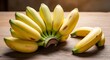 © Encep - Bunch of Delicious Lady Finger Bananas on Wooden Surface.