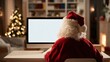 © The Little Hut - Santa Claus Working on Computer at Home During Christmas Season with Blank Screen
