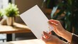 © Imam - Female hands holding blank white menu in cozy cafe with natural light, ideal mockup for restaurant branding, flyer, or menu design presentation.