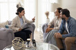 © fizkes - Confident smiling female psychological therapist consult family couple in office
