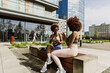 © Drobot Dean - Two female athletes sitting on a bench holding cups while one of them laughs