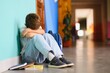 © Serhii - Upset boy sitting at school and crying after bullying by pupils classmates